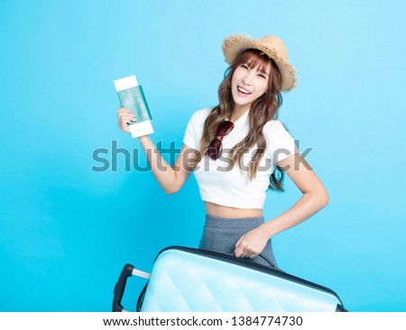 happy tourist woman in summer hat holding  passport and suitcase