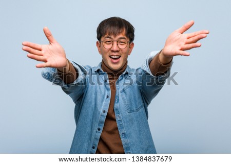 Young chinese man very happy giving a hug to the front