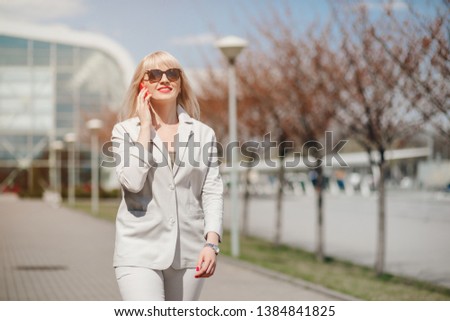 Portrait of Beautiful Woman in office clothes using smart phones. Business Woman with phone near office. Phone Communication.