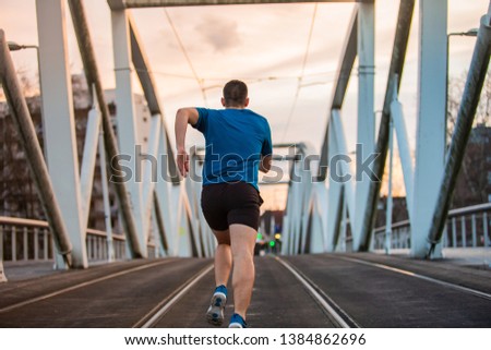 Male athlete running, exercising indoors, jogging rear view, full length. Self overcome concept. Workout concept .Healthy lifestyle.