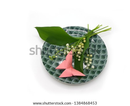 Lily of the valley Convallaria majalis flower and leaves isolated on white background. Pink butterfly and fragrant lilly of the valley.
