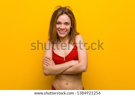 Young caucasian woman wearing bikini and sunglasses laughing and having fun.