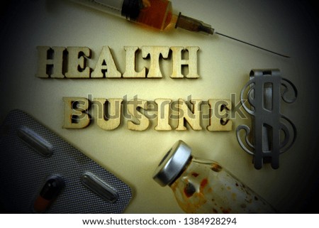 Medical concept. Inscription Health business from wooden letters next to a pill, syringe and dollar symbol. Vignetting