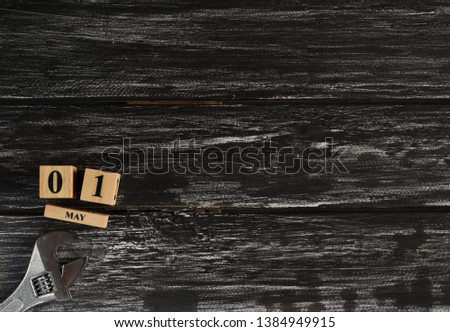 May 1 text wooden block calendar and adjustable wrench on black wooden background for Worker day, Labor day, labour day.