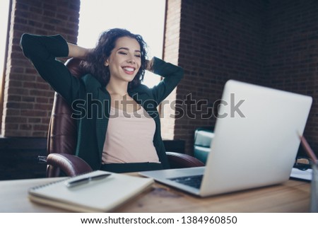 Close up photo of cute funny charming real estate agent enjoy leisure feel glad content have news in modern technology sit armchair jacket place hands arms behind head neck desktop in interior