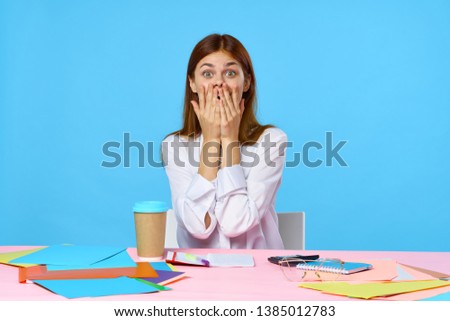 Emotional woman covers hands over face table coffee blue background