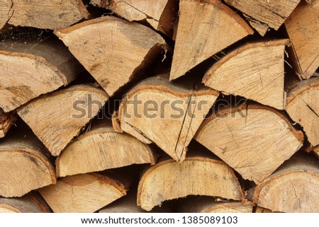 Firewood piles stacked together textured wooden background. Close up.