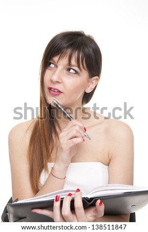 young thinking business woman writing on a notepad on white background