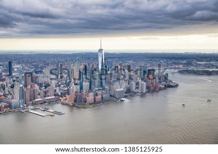 New York City from helicopter point of view. Downtown Manhattan, Jersey City and Hudson River on a cloudy day.