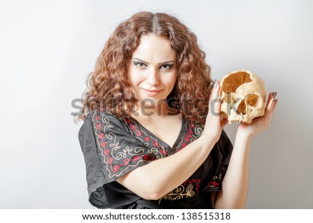Picture of a witch with a scull in hand on white horizontal