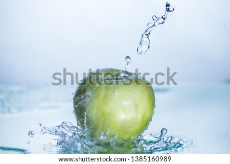 Green apple with freezed water splash and drops without image editing and retouch.