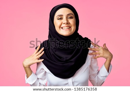 woman hijab in a black burqa on a pink background                              