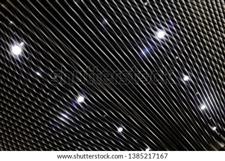 Grid, louvered or lath structure of drop ceiling with spot lights. Hi-tech industry or office building interior with striped pattern. Abstract modern architecture background in black and white.