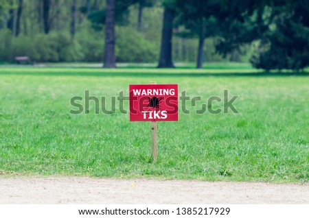 The sign on the lawn with the inscription: warning ticks.
