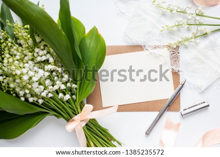 Mockup with postcard and lilies of the valley on white background card and lilies of the valley 