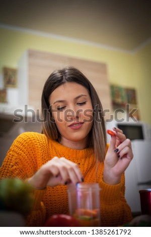 Woman making smoothie at kitchen.