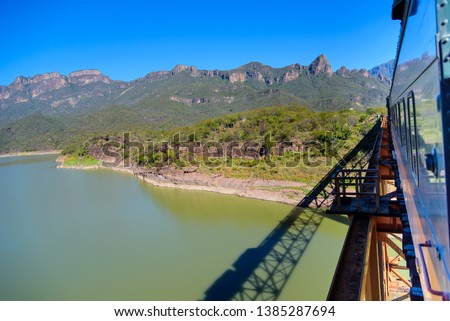 wagons of the Chepe train moving on bridge over river road to Barrancas del Cobre in Chihuahua, Mexico