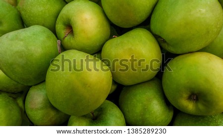 Close-up pictures of green apples as a background.