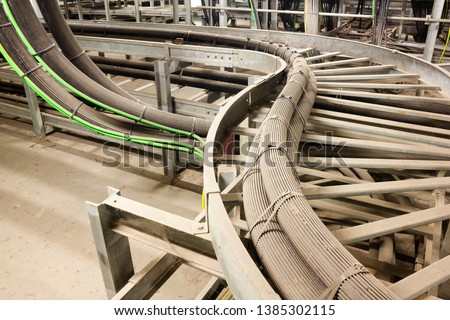 Install high voltage power cable in trefoil formation on cable ladder and fix with stainless cable tie Royalty-Free Stock Photo #1385302115