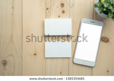 ฺBlank white screen smartphone and business card mockup on wood table and copy space background 