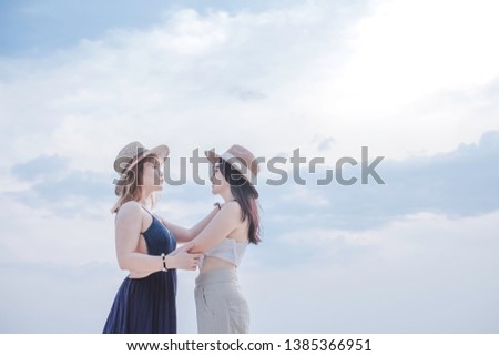 Portrait of happy Asian woman on the beach. The young lesbian couple enjoying vacation time at beautiful sea.  On summer holiday you can see cheerful people traveling at the ocean. LGBT concept. 