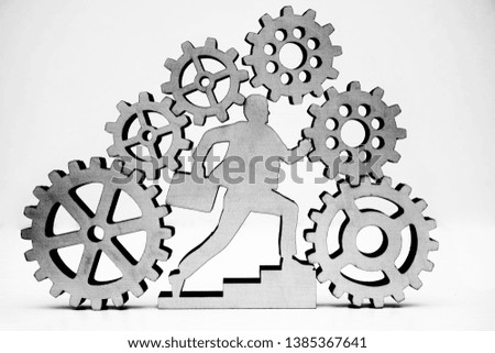 businessman with case running inside many big and small gear wheel, cogwheel isolated on white background. wooden sign, symbol of business man. missing part