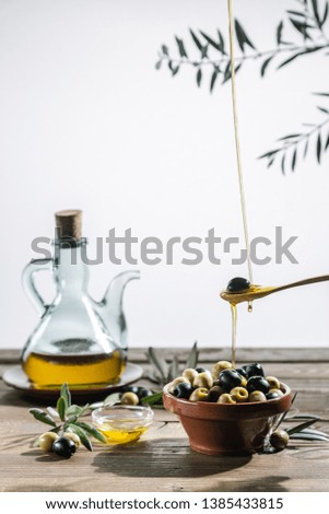 Olive oil and olive branch on the wooden table 