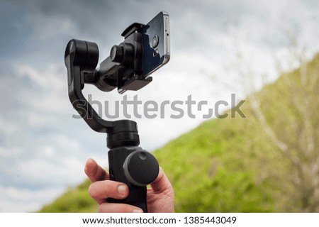 Close-up of man shoots video on phone using an image stabilizer