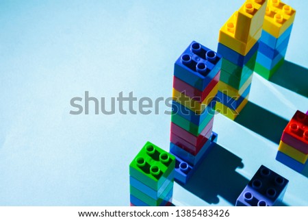 Columns from the children's designer on a blue background. The concept of building houses, new building. Flat lay, top view.