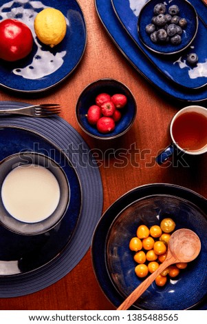 Blue ceramic tableware with fruit and milk