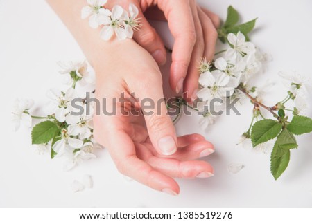 Woman hand close up with spring flowers. Fashion feminine natural skincare.