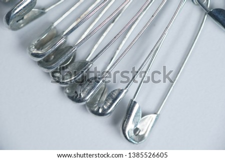 a stack of metal safety pins on isolated white background