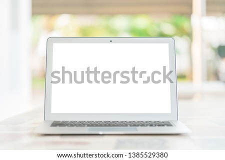 Outdoor remote working by light gray color laptop computer with white screen and copy space on granite texture desk and garden green tree background