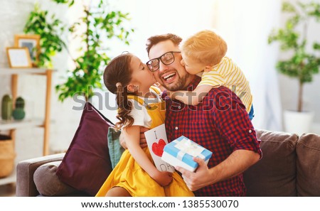 Happy father's day! Children congratulates dad and gives  him a gift and postcard 
