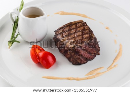 Beef steak with spices served on a dish of white background. A piece of tenderloin beef. Filet Mignon.