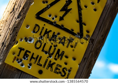 "danger of death" warning sign on the pole, deformed,