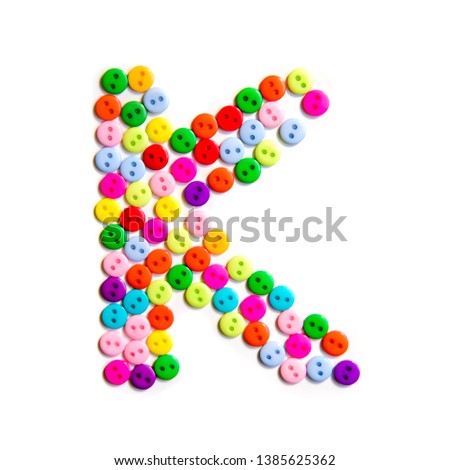 Letter K of the English alphabet from a group of colorful small buttons on a white background