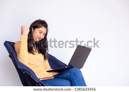 Smart beautiful young woman in jeans using laptop sit on chair isolated on white background.