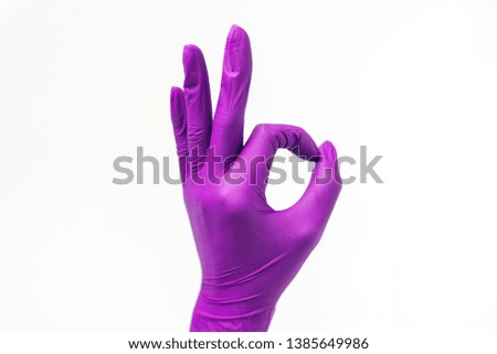 Protective purple gloves, isolated on white background. Ok sign gesture.