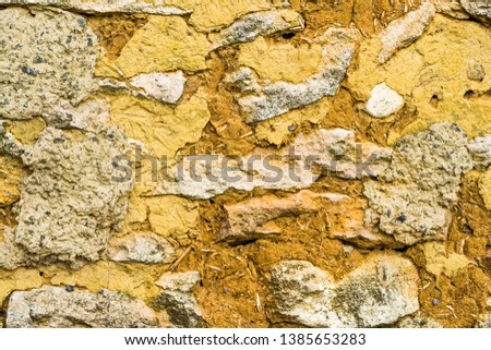 The texture of the rustic wall. Old plaster wall made of clay and wild stone. Vintage shabby walls for screen saver