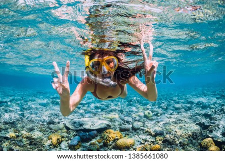 Happy young woman swimming underwater in tropical sea. Snorkeling in Indian ocean Royalty-Free Stock Photo #1385661080
