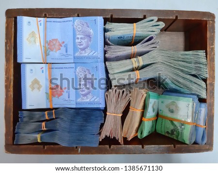 Bundle of money. Malaysia Ringgit (MYR) RM100, RM50, RM20, RM10, RM5, RM1 in the old wooden box.