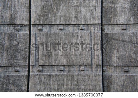 Part of an old wooden fence with a repeating pattern of gray-brown color, taking up the entire area of photography