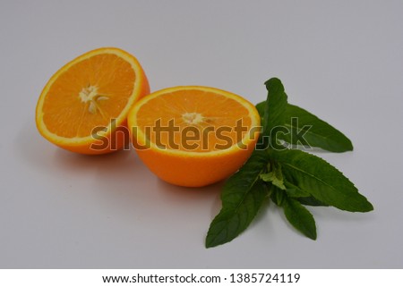 Bright two orange halves of sliced ripe and juicy orange with a sprig of fresh mint. Healthy food and fruit, healthy food.