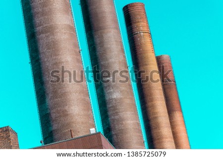 Abstract deliberately crooked image of the chimneys of the power plant of a large industrial plant, oblique