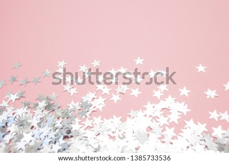 Star-shaped confetti scattered on a pink background. Celebration and party, concept. Copy space, glitter