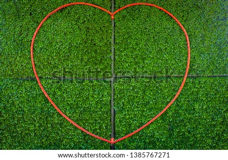 chains forming into a heart lay down on the green plastic leaves