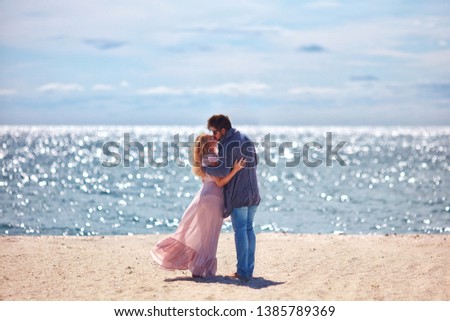 beautiful young couple kissing on sandy beach at summer day