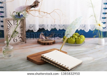Notepad and quill pen on the desk.