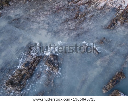 Aerial Shoot Rocks and Waves with blue water from the sky view